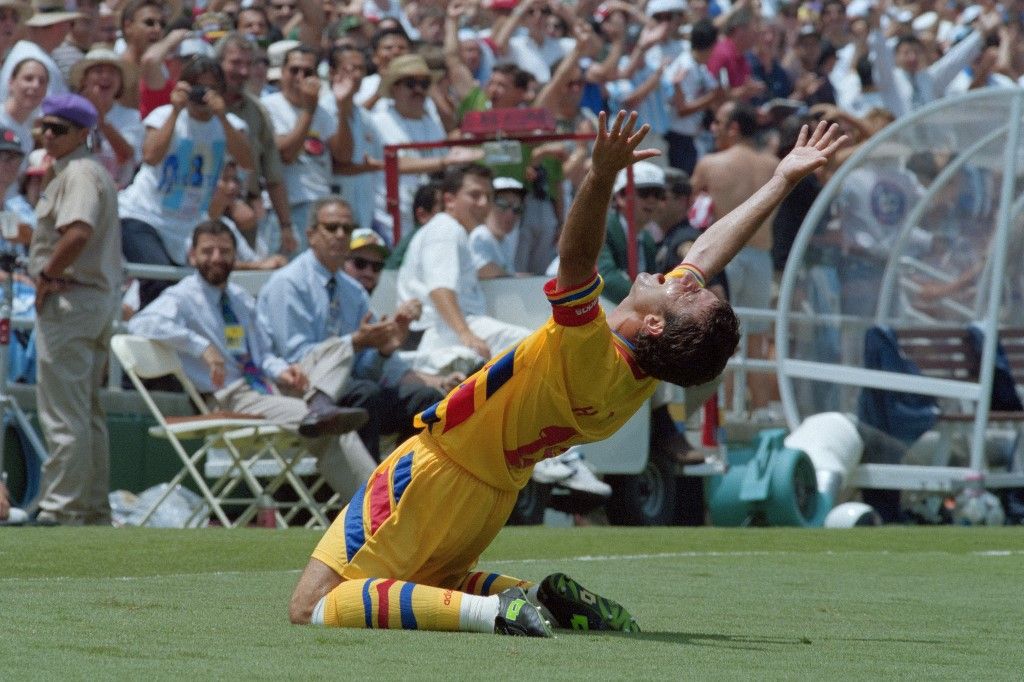 Romanian captain Gheorghe Hagi celebrates after his teammate Ilie Dumitrescu scored the first of his two goals during the World Cup second round game between Argentina and Romania on July 3, 1994 at Pasadena's Rose Bowl stadium. Romania won 3-2 and qualifies for the quarter-final against Sweden. The 15th FIFA World Cup took place in 1994. The United States hosted the event, which was held at nine locations nationwide from June 17 to July 17, 1994. Despite soccer's relative lack of popularity in the host country, the United States was selected, and the competition was the most profitable in World Cup history. (Photo by Gabriel BOUYS / AFP)