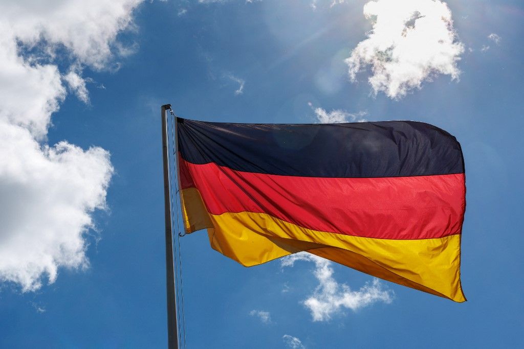 19 May 2026, Bavaria, Munich: A German flag flies in the wind against a slightly cloudy sky in Munich (Bavaria, Germany) on May 19, 2026. The German flag, officially the federal flag, is a German national emblem and state symbol and shows the colors black, red and gold according to the Basic Law. In addition to the federal flag, there is also the federal service flag for federal authorities, a service flag for the naval forces and a troop flag for the German armed forces. (symbol image, symbol photo, illustration, symbolic photo, illustrative photo, theme image, general image, theme photo, state symbol, nationality) Photo: Andreas Arnold/dpa (Photo by Andreas Arnold / dpa Picture-Alliance via AFP)