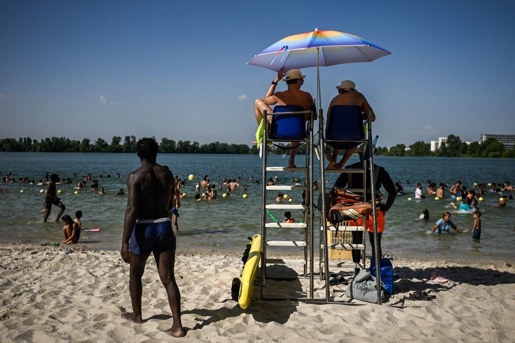 Lifeguards keep watch from their station over a packed lake beach during a heatwave at the Bordeaux Lac beach, in Bordeaux, south-western France on June 23, 2026. France on June 23, 2026 experienced its hottest day since measurements began in 1947, the na