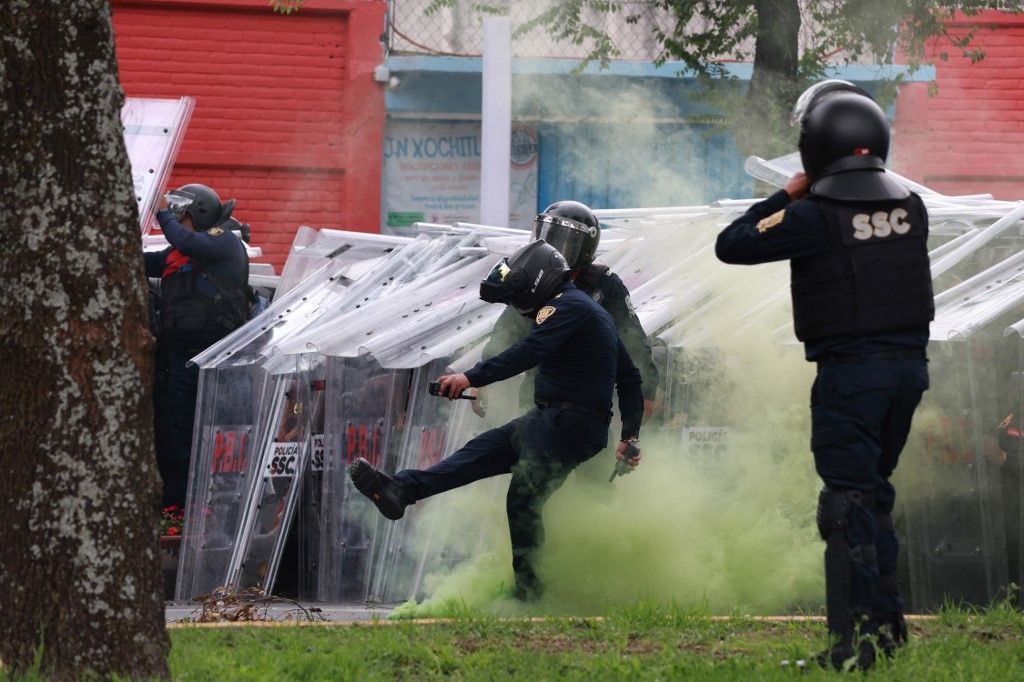 MEXICO CITY, MEXICO - JUNE 11: Riot police use shields to protect themselves during clashes with demonstrators near Banorte Stadium, in Mexico City, Mexico on June 11, 2026. Thousands of demonstrators marched toward Banorte Stadium to protest against the World Cup, while some clashed with riot police outside the stadium where the World Cup opener was taking place. Daniel Cardenas / Anadolu (Photo by Daniel Cardenas / Anadolu via AFP)