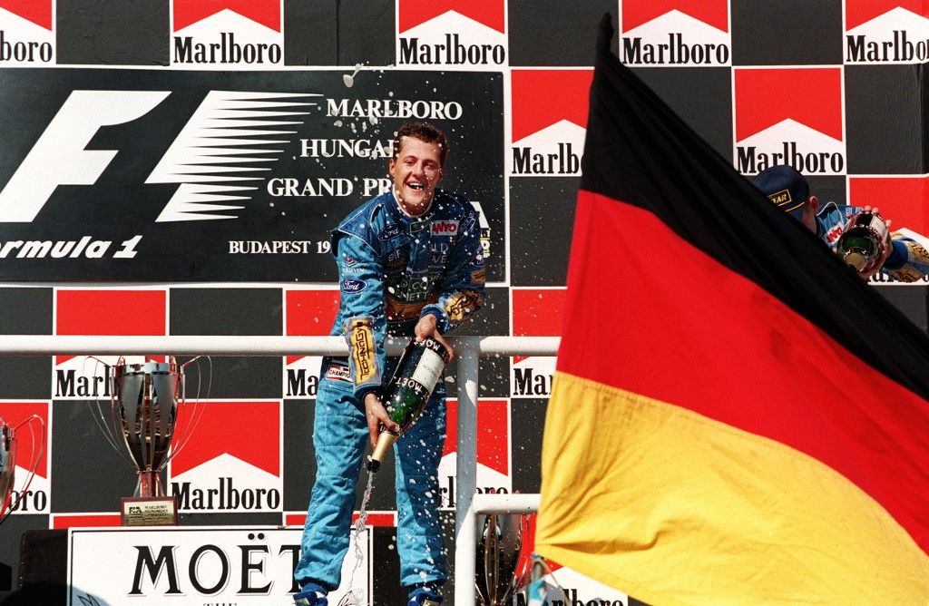 German formula-1 driver Michael Schumacher sprirts champagne after winning the Hungarian formula one Grand-Prix, 14 August 1994 at the Hungaroring.      AFP PHOTO JEAN-LOUP GAUTREAU (Photo by JEAN-LOUP GAUTREAU / AFP)