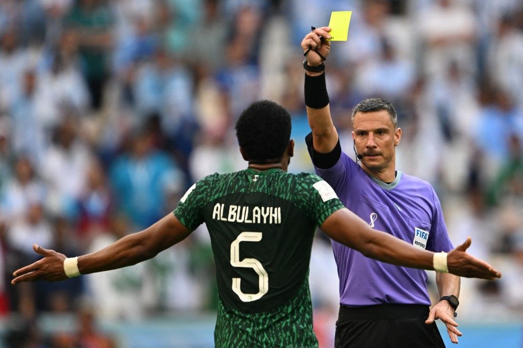 Slovenian referee Slavko Vincic (R) shows a yellow card to Saudi Arabia's defender #05 Ali Al-Bulaihi during the Qatar 2022 World Cup Group C football match between Argentina and Saudi Arabia at the Lusail Stadium in Lusail, north of Doha on November 22, 2022. (Photo by Kirill KUDRYAVTSEV / AFP)