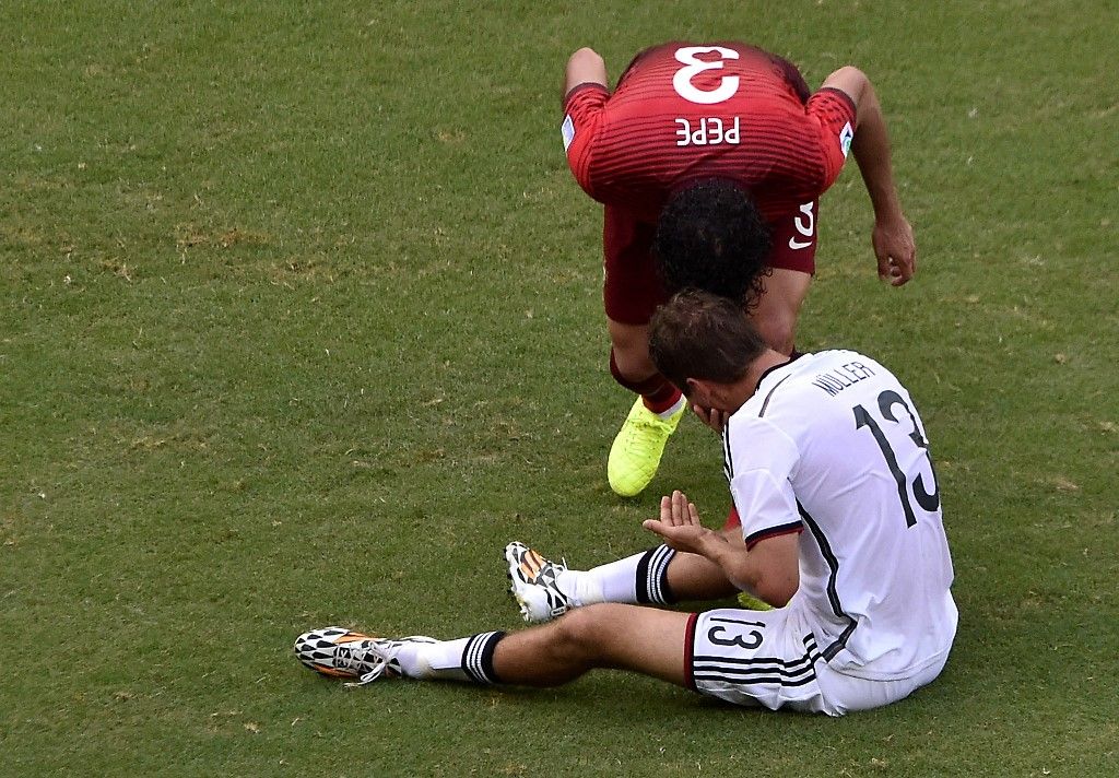 Portugal's defender Pepe fouls Germany's forward Thomas Mueller (front) to be send off during the Group G football match between Germany and Portugal at the Fonte Nova Arena in Salvador during the 2014 FIFA World Cup on June 16, 2014. AFP PHOTO / DIMITAR DILKOFF (Photo by DIMITAR DILKOFF / AFP)