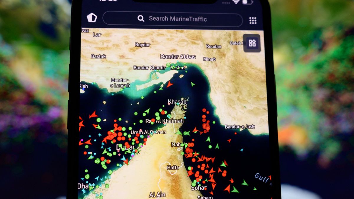 A smartphone screen displaying the MarineTraffic map shows a high concentration of ship beacons in the Strait of Hormuz in Creteil, France, on March 27, 2026. This occurs amid heightened tensions related to incidents involving Iranian drones and oil tankers. (Photo by Samuel Boivin/NurPhoto) (Photo by Samuel Boivin / NurPhoto via AFP)