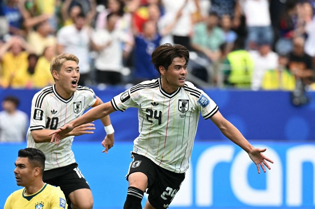 Japan's midfielder #24 Kaishu Sano (R) celebrates   after scoring the opening goal during the 2026 World Cup round of 32 football match between Brazil and Japan at the Houston Stadium in Houston on June 29, 2026.  (Photo by Paul ELLIS / AFP)