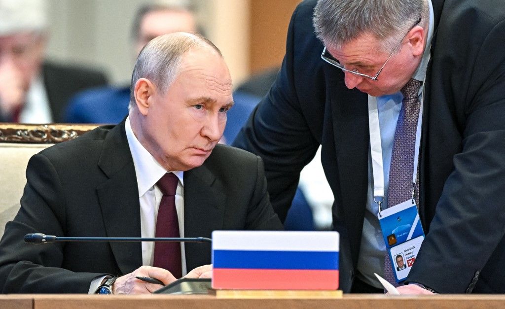 In this pool photograph distributed by the Russian state agency Sputnik Russia's President Vladimir Putin (L) talks to Russia's Deputy Prime Minister Alexey Overchuk during the extended-format meeting of the Supreme Eurasian Economic Council of the Eurasian Economic Union (EAEU) at the Palace of Independence in Astana on May 29, 2026. The Russian president is on a state visit to Kazakhstan. (Photo by Sergey Bobylev / POOL / AFP)