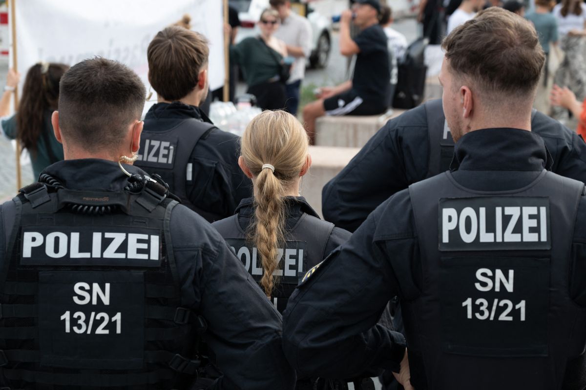 17 July 2026, Saxony, Dresden: Police officers are standing in front of the Higher Regional Court (OLG) and observing a rally. A verdict is expected in the trial of Susann E., an alleged NSU supporter. Photo: Sebastian Kahnert/dpa (Photo by Sebastian Kahnert / dpa Picture-Alliance via AFP)