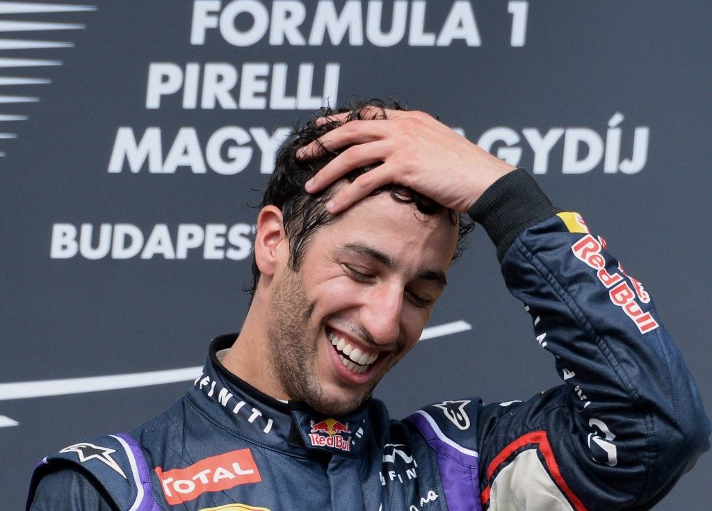 Red Bull Racing's Australian driver Daniel Ricciardo celebrates on the podium after the Hungarian Formula One Grand Prix at the Hungaroring circuit in Budapest on July 27, 2014. Red Bull Racing's Australian driver Daniel Ricciardo won the race ahead of Scuderia Ferrari's Spanish driver Fernando Alonso (2nd) and Mercedes' British driver Lewis Hamilton (3rd). AFP PHOTO / ATTILA KISBENEDEK (Photo by ATTILA KISBENEDEK / AFP)