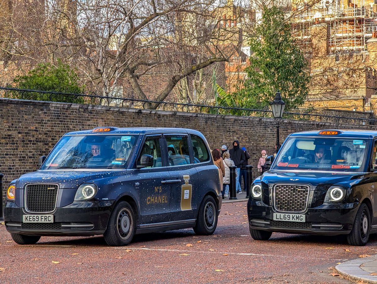 Two taxis drive along a red-surfaced road in the City of Westminster, London, United Kingdom, on December 24, 2025. (Photo by Michael Nguyen/NurPhoto) (Photo by Michael Nguyen / NurPhoto via AFP)