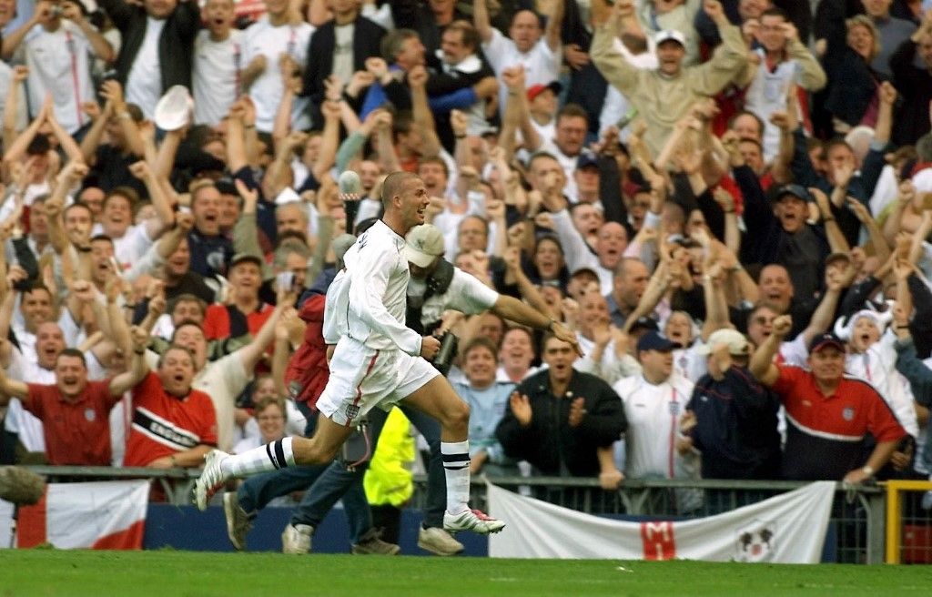 England captain David Beckham celebrates with fans after scoring their winning goal 06 October 2001, in Englands victory over Greece to qualify for the 2002 World Cup finals , at Old Trafford. AFP PHOTO GERRY PENNY/GP-BW (Photo by GERRY PENNY / AFP)