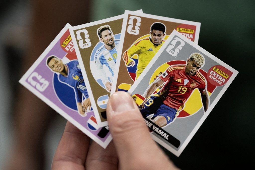 A worker shows collectible cards of (From L) Frances forward Kylian Mbappé, Argentinas forward Lionel Messi, Colombia's forward Luis Diaz and Spains forward Lamine Yamal for the upcoming 2026 FIFA World Cup hosted by the US, Canada and Mexico, at the Panini Group factory in Modena, northern Italy, on April 28, 2026. (Photo by MARCO BERTORELLO / AFP)