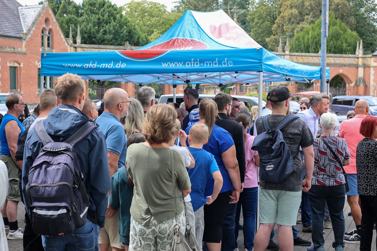 28 July 2026, Saxony-Anhalt, Magdeburg: People are standing at the AfD information booth during a visit by Ulrich Siegmund (third from the right), the AfD's top candidate for the state election in Saxony-Anhalt. Photo: Peter Gercke/dpa (Photo by Peter Gercke / dpa Picture-Alliance via AFP)
