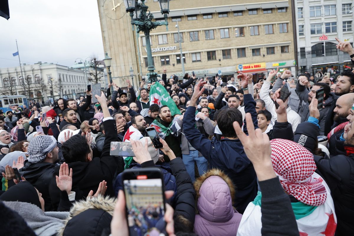 Members of the Syrian community hold Syrian opposition flags as they rally on December 8, 2024 in Gothenburg, Sweden, to celebrate the end of Syrian dictator Bashar al-Assad's rule after rebel fighters took control of the Syrian capital Damascus overnight. Islamist-led rebels toppled Syria's longtime ruler Bashar al-Assad in a lightning offensive that a UN envoy called "a watershed moment" for the nation marred by civil war. (Photo by Adam IHSE / TT News Agency / AFP) / Sweden OUT