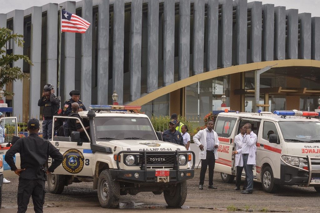 Liberia's national police officers stand guard for a plane carrying migrants deported from the US at the Roberts International Airport in Harbel, some 56 km outside of Liberia's capital of Monrovia, on August 20, 2026. Twenty migrants deported from the United States arrived in Liberia on August 20, AFP journalists saw, the first of up to 1,200 foreign nationals the west African country has agreed to accept. Liberia is the latest African country to agree to take in migrants deported under US President Donald Trump's contested immigration crackdown. (Photo by Matthew Jacobs / AFP)