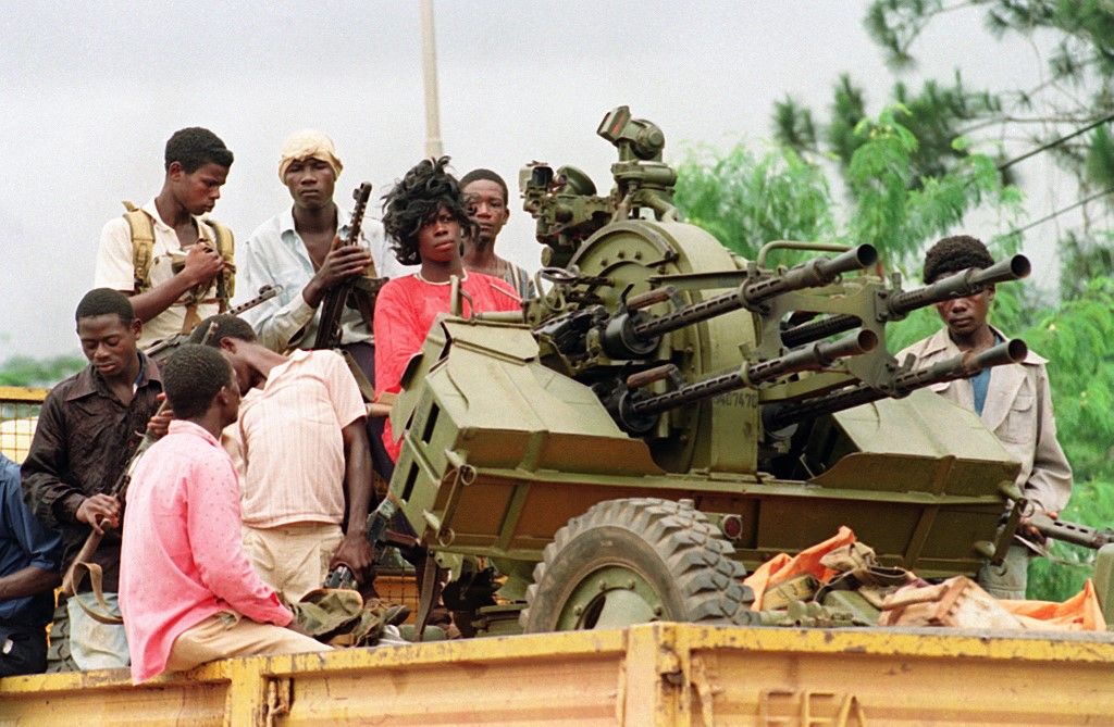 Rebels loyal to warlord Charles Taylor of the National Patriotic Front of Liberia (NPFL) patrol with an anti-aircraft gun in the streets of Monrovia 21 August 1990 during the fighting with the Armed Forces of Liberia (AFL). In December 1989 an armed insurrection by rebel forces began in the north-eastern border region of Nimba County. In early 1990 several hundred death ensued in fighting between the AFL and rebels, who claimed to be members of a hitherto unknown opposition group the NPFL, led by a former government official, Charles Taylor. NPFL forces entered Monrovia in July. AFP PHOTO PASCAL GUYOT (Photo by PASCAL GUYOT / AFP)