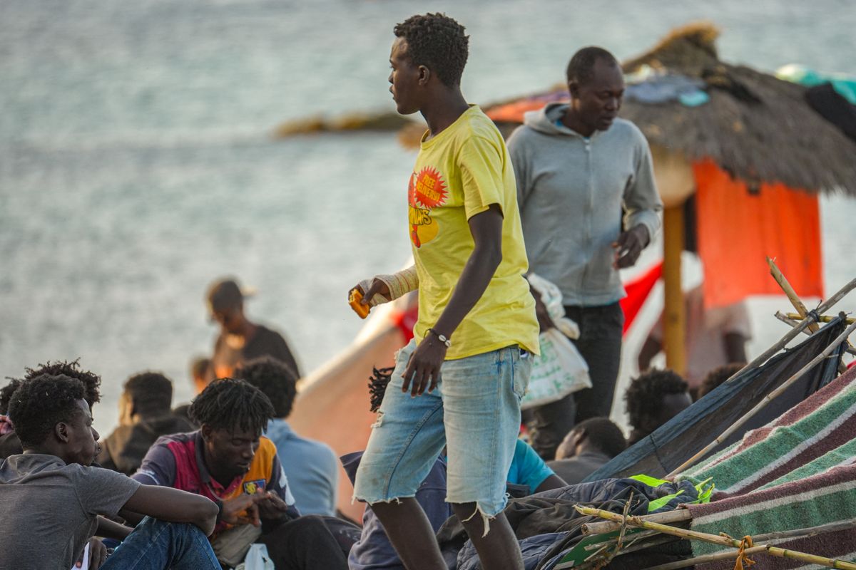 A migrant walks on El Trampolin beach in Ceuta, Spain. Migrants sleep outdoors on the beach while waiting for food and institutional assistance with their documentation. (Photo by Ana Lopez/NurPhoto) (Photo by Ana Lòpez / NurPhoto via AFP)