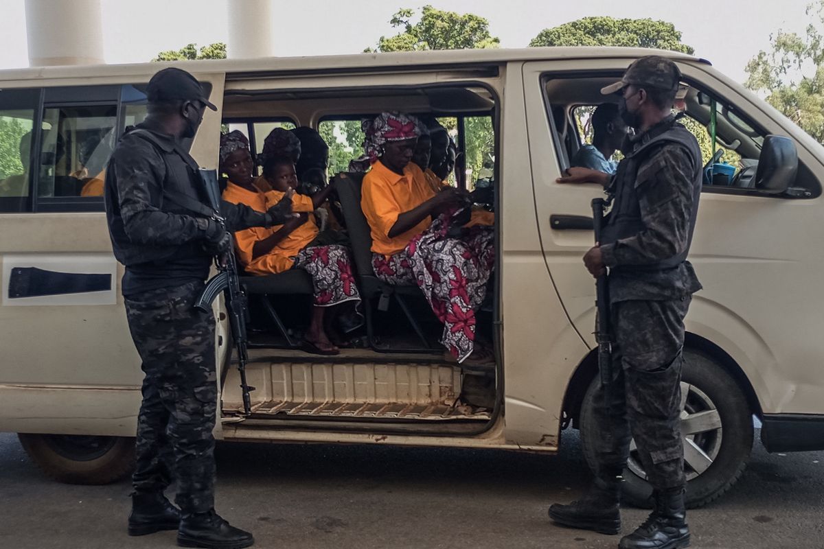 Security officers stand guard next to a bus carrying freed worshippers at the Government House in Kaduna on February 5, 2026. More than 160 Christian worshippers were initially feared kidnapped during coordinated attacks on three churches in Kurmin Wali, Kajuru area, on January 18. Authorities said dozens later returned after fleeing during the assault, while others were rescued and brought to the government residence. (Photo by AFP)