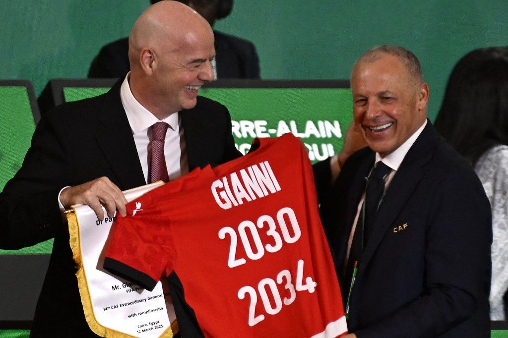 President of Egyptian Football Association Hany Abo Rida (R) presents the President of Fédération Internationale de Football Association (FIFA) Gianni Infantino with a jersey during the Confederation of African Football (CAF) general assembly and the election of a new executive committee, in Cairo, on March 12, 2025. (Photo by Khaled DESOUKI / AFP)