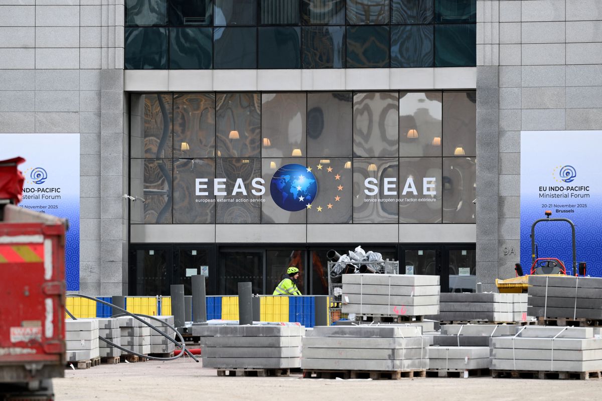 A cyclist rides past the European External Action Service (EEAS) building, which hosts the diplomatic service of the European Union, in Brussels on December 2, 2025. Three people were arrested on December 2, 2025 following raids on EU offices and a prestigious graduate school in a probe into suspected fraud linked to the training of future diplomats, prosecutors said. (Photo by Nicolas TUCAT / AFP)