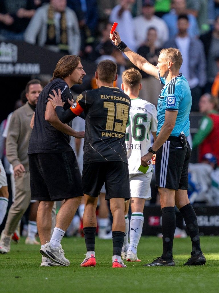 05 September 2026, North Rhine-Westphalia, Mönchengladbach: Soccer, Men: Bundesliga, Borussia Mönchengladbach vs. SV Elversberg, Matchday 2, ista-Borussia-Park Stadium: Referee Martin Petersen (right) shows coach Vincent Wagner (SV 07 Elversberg) a yellow-red card. Photo: David Inderlied/dpa - IMPORTANT NOTICE: In accordance with the regulations of the Bundesliga and the German Football Association (DFB), it is prohibited to use or allow the use of photographs taken in the stadium and/or during the game in the form of sequential images and/or video-like photo series. (Photo by David Inderlied / dpa Picture-Alliance via AFP)