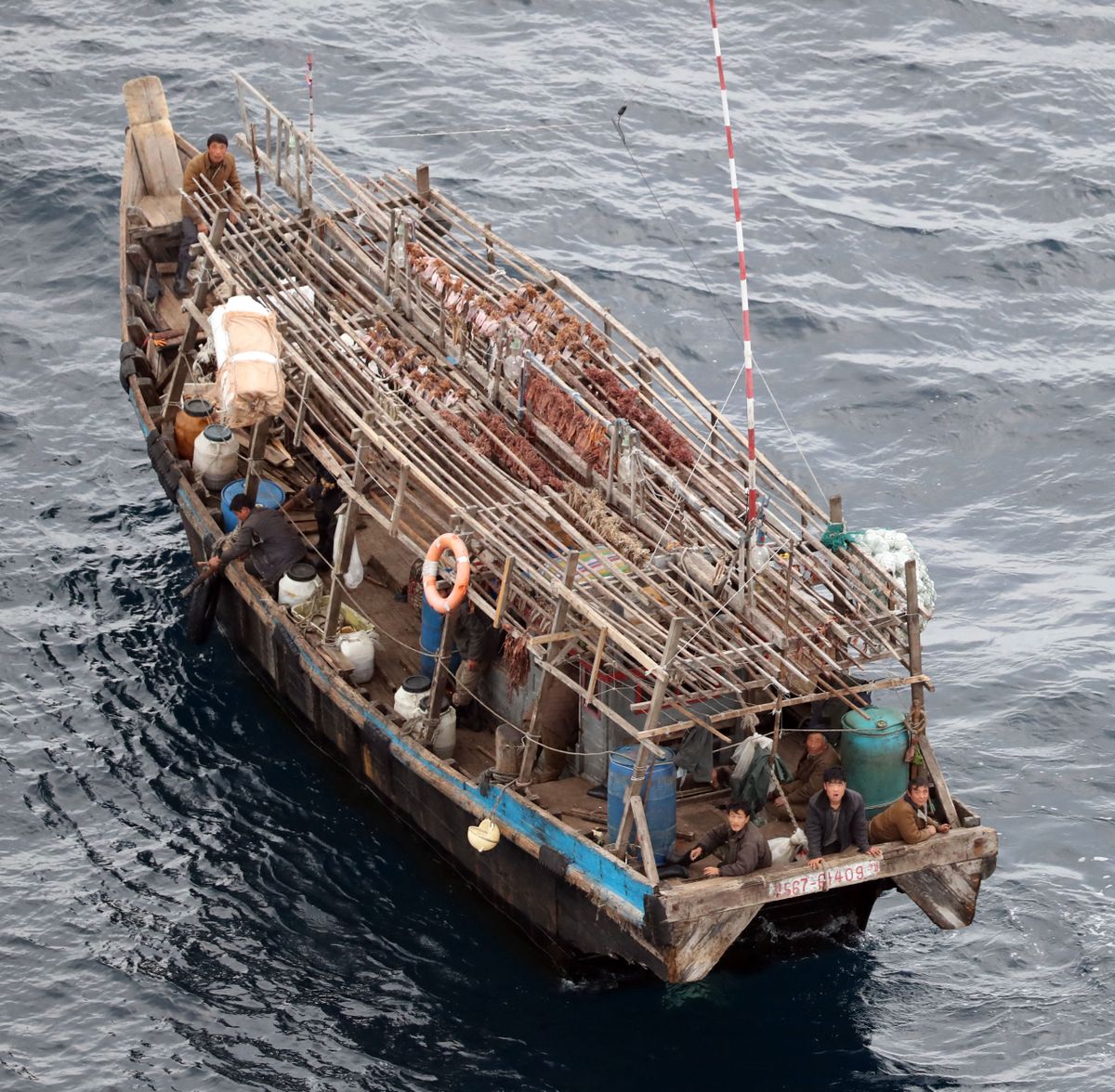A photo shows a fish boat that seems to be unknown nationality at about 310 km northwest off the coast of Noto Peninsula, Ishikawa Prefecture on October 7, 2019. The crew looked up, and squids have been dried on the roof.   ( The Yomiuri Shimbun ) (Photo by Ryohei Moriya / The Yomiuri Shimbun via AFP)