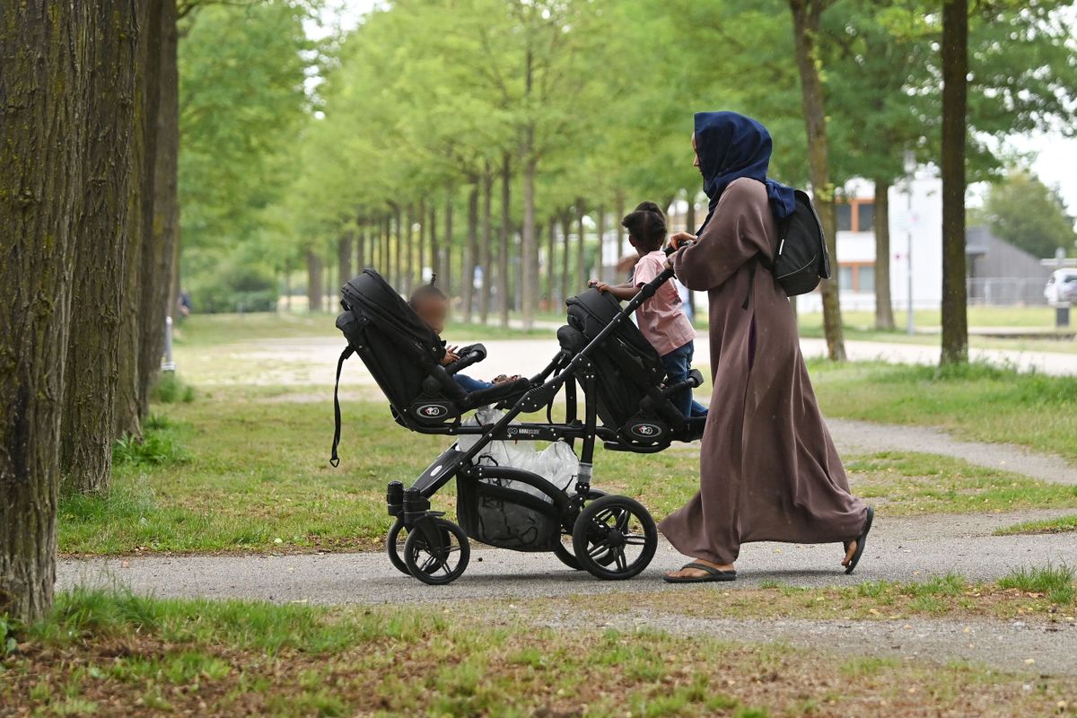 Muslim woman with headscarf, mother in traditional dress and headscarf with her daughters, child; children, migrants, migrant, migrant. Stroller, ? (Photo by Frank Hoermann/SVEN SIMON / SVEN SIMON / dpa Picture-Alliance via AFP)