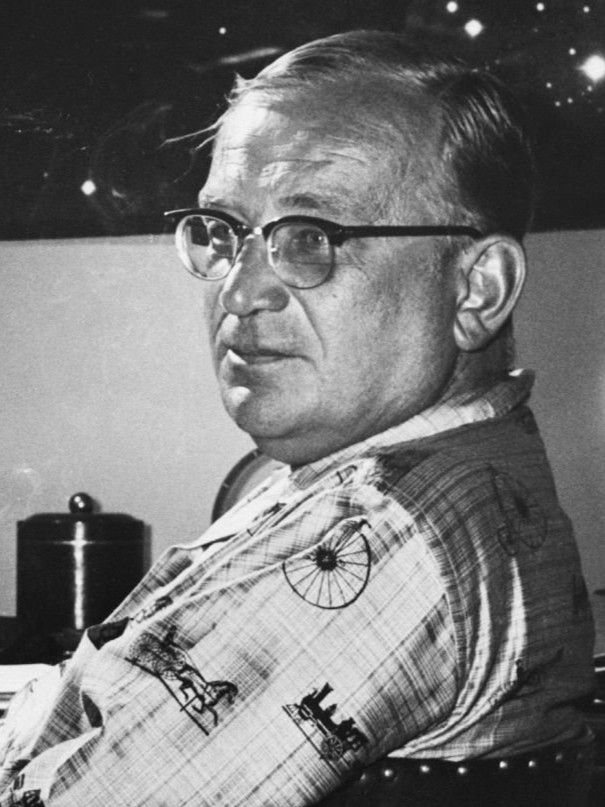 (Original Caption) Relaxing in his apartment in the University Club, George Gamow takes five for a cigarette from the strenuous task of editing material for his college text, "Matter, Earth, And Sky". The celestial photograph behind Gamow was made for him at Convair while he was working there as a part time consultant.