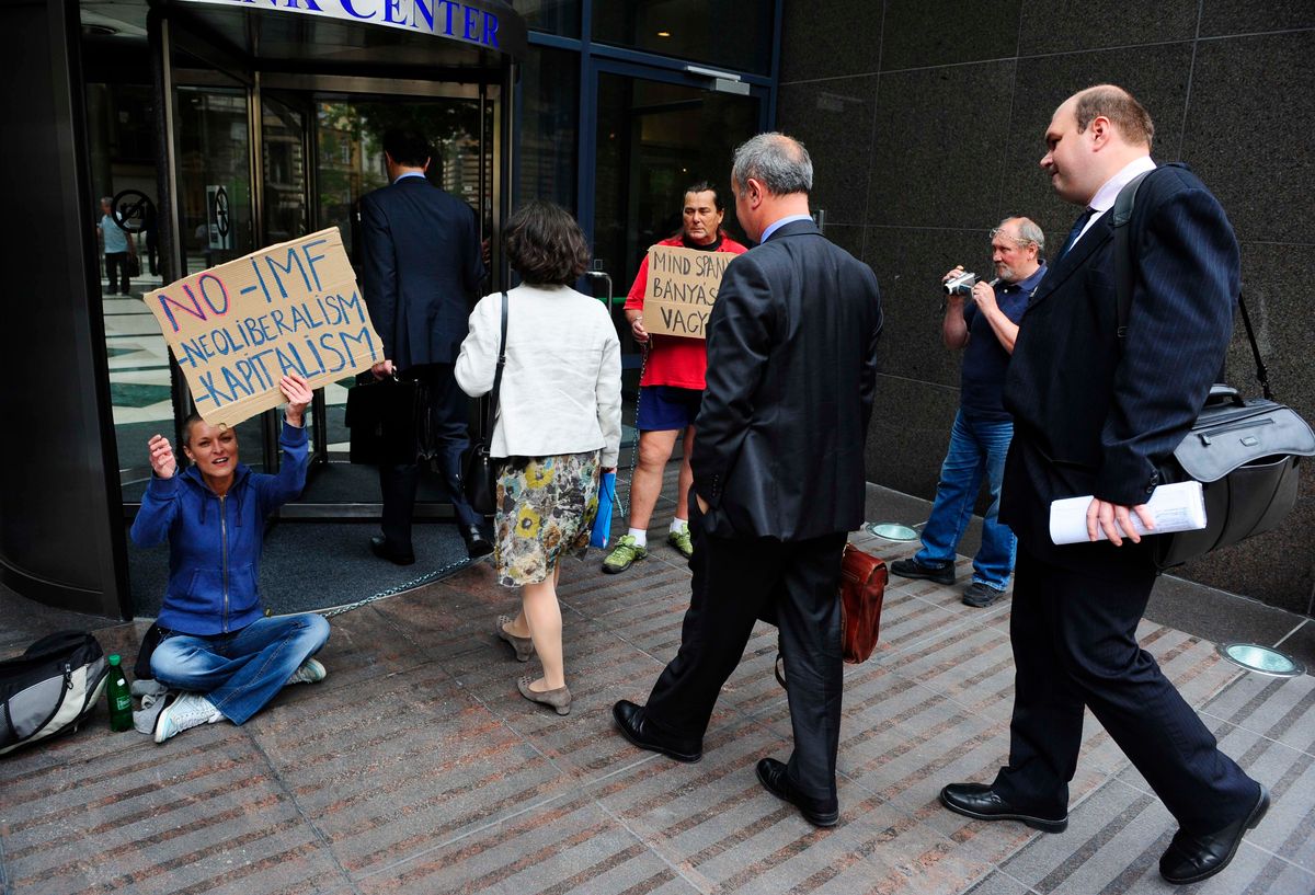 2012. július 17. Thanos Arvanitis, a Nemzetközi Valutaalap (IMF) delegációjának vezetője, és Barbara Kauffmann, az Európai Bizottság (EB) delegációjának vezetője Bank Center épületének bejáratához érkeznek - ahol az IMF budapesti képviselete is található -, ahová civilek láncolták magukat. A most kezdődő EU/IMF-tárgyalások ellen tiltakozó, be nem jelentett ülősztrájk résztvevőit a rendőrség előállította. Fotó: Kurucz Árpád