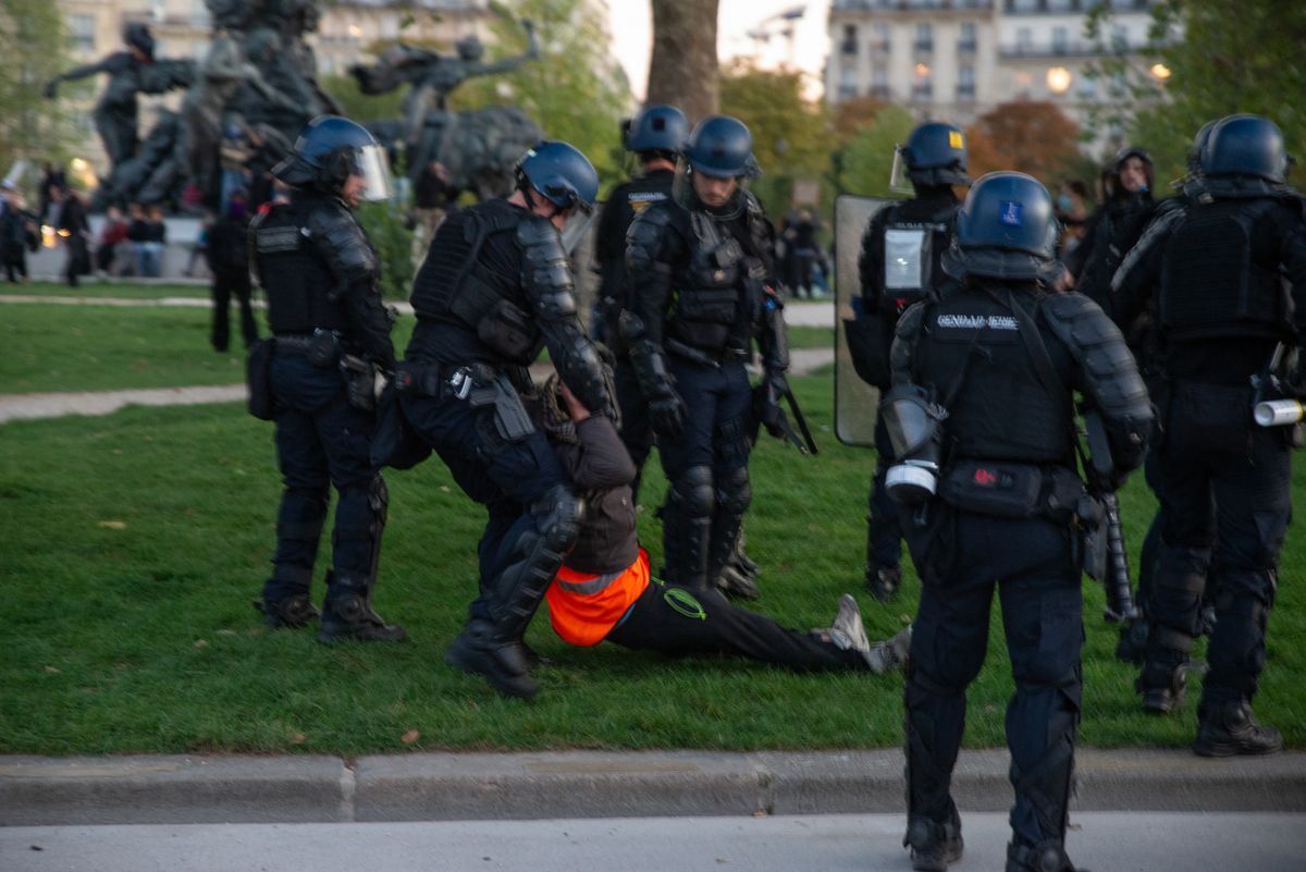 Riot police drag a demonstrator by the arms and legs across the grass in Paris, France, on October 8, 2026. France's Interior Ministry said 71,500 people demonstrated nationwide, including 24,500 in Paris, as students demanded more staff, resources and improved school conditions; police used tear gas and water cannon during clashes at Place de la Bastille later in the day. (Photo by Davood Maeili / Middle East Images via AFP)